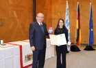 Regierungspräsident Dr. Eugen Ehmann überreichte die Ordensinsignien und ein Geschenk an Nele Gößwein.